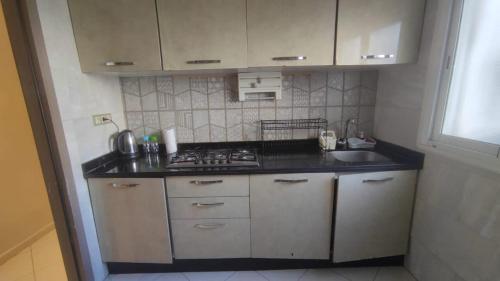 a small kitchen with a stove and a sink at Mounia Moon in Casablanca