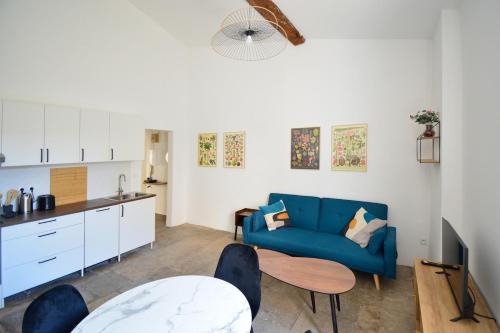 un salon avec un canapé bleu et une table dans l'établissement Ecusson - Centre Historique, à Montpellier