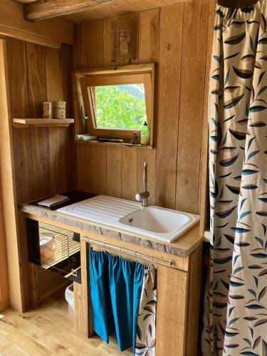 une salle de bain avec un lavabo et une fenêtre dans l'établissement Cabane insolite Les Vargottes, à Le Val-dʼAjol