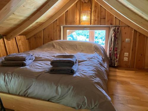 un lit dans une chambre avec un plafond en bois dans l'établissement Cabane insolite Les Vargottes, à Le Val-dʼAjol