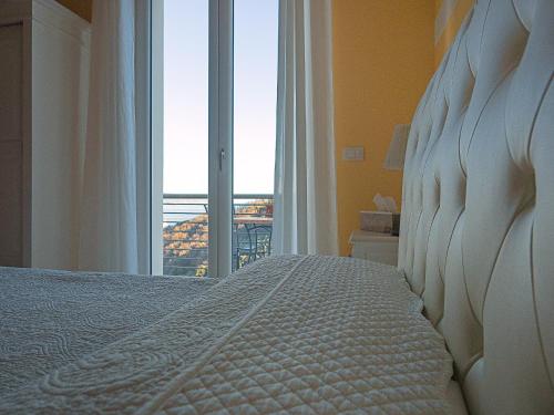 a bedroom with a bed with a large window at Agriturismo La Pietra 1 e La Pietra 2 in La Spezia