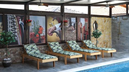 a group of chairs sitting next to a swimming pool at Ruralna kuća za odmor Didovina Sinj in Sinj