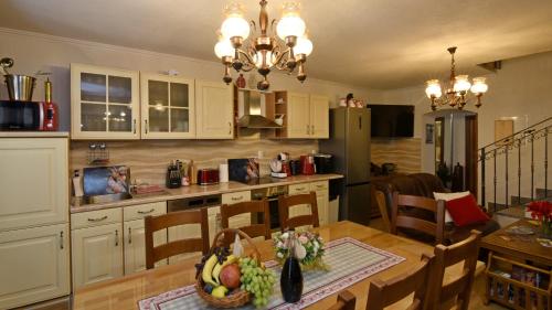 a kitchen and dining room with a table with a bowl of fruit at Ruralna kuća za odmor Didovina Sinj in Sinj