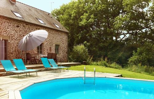 une piscine avec des chaises et un parasol à côté d'une maison dans l'établissement Mill House Gite, à Villaines-la-Juhel