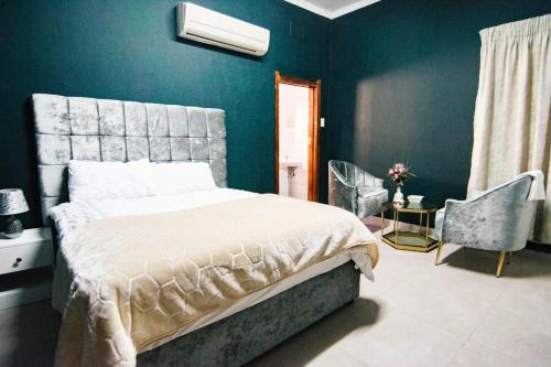 a bedroom with a bed and a blue wall at Skypz Home Lodge in Johannesburg