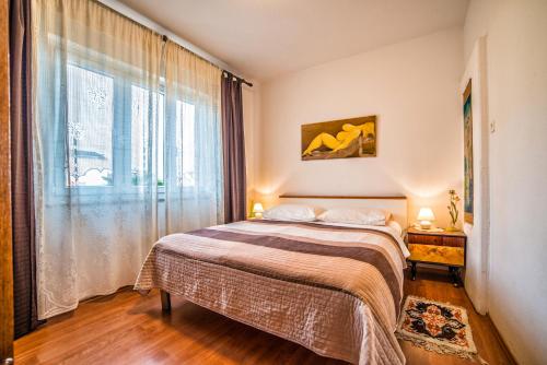 a bedroom with a bed and a large window at Apartment Iva in Rovinj