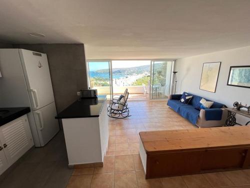 un salon avec un canapé bleu et une table dans l'établissement Cadaqués and Chill, à Cadaqués