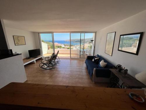 un salon avec un canapé bleu et une télévision dans l'établissement Cadaqués and Chill, à Cadaqués