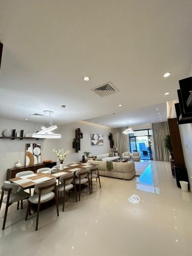 a dining room and living room with a table and chairs at The Riviera Luxury Villa - Seaview Al Dana Fujairah in Fujairah