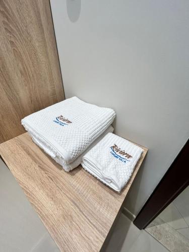 two white towels are sitting on a table at The Riviera Luxury Villa - Seaview Al Dana Fujairah in Fujairah
