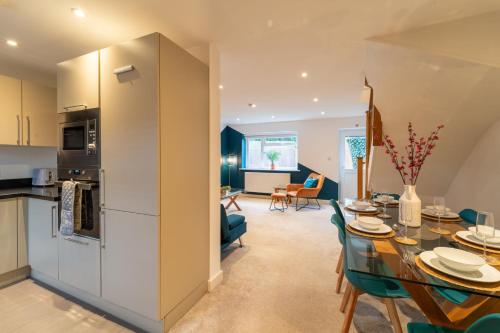 a kitchen and living room with a table and chairs at Huge Monthly Savings - Private Parking - WiFi in Gloucester