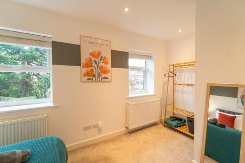 a childs room with a blue couch and windows at Huge Monthly Savings - Private Parking - WiFi in Gloucester