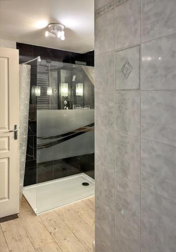 La salle de bains est pourvue d'une douche et d'une paroi en verre. dans l'établissement Maison de campagne spacieuse à Chastreix avec cheminée, à Chastreix