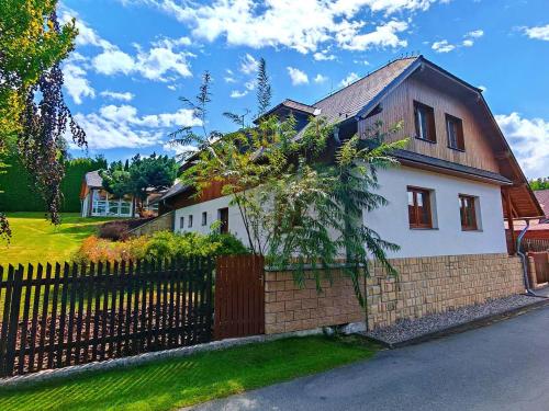a white house with a brick fence in a yard at Chalupa Širůček Budislav in Budislav