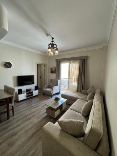 a living room with a couch and a television at Apartment with private Beach in Sahl Hasheesh in Hurghada
