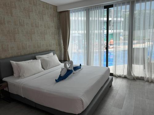 a bedroom with a bed with a stuffed animal on it at Direct pool access studio Twin Sands by Lofty in Patong Beach