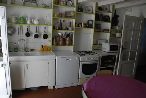 Il comprend une cuisine équipée d'une cuisinière blanche et d'un évier. dans l'établissement Agréable maison de vacances, à Quimiac