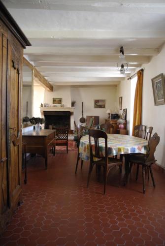 un salon avec une table et des chaises et une cheminée dans l'établissement Agréable maison de vacances, à Quimiac