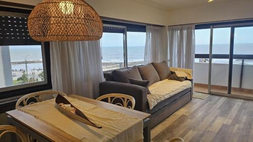 a living room with a couch and a table at Frenta al mar, vista a la playa in Mar del Plata