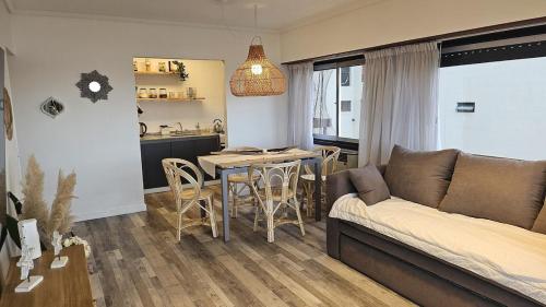 a living room with a couch and a table at Frenta al mar, vista a la playa in Mar del Plata