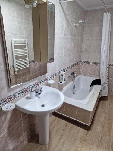 a bathroom with a sink and a bath tub at Apartamento Noa in Muxia