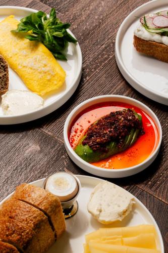 a table topped with plates of food with bread and cheese at 4 Strony Apartamenty w Wodnej Wieży in Pszczyna