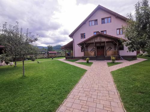 CosteştiにあるCasa Ceciliaの芝生の庭のある大きなピンクの家