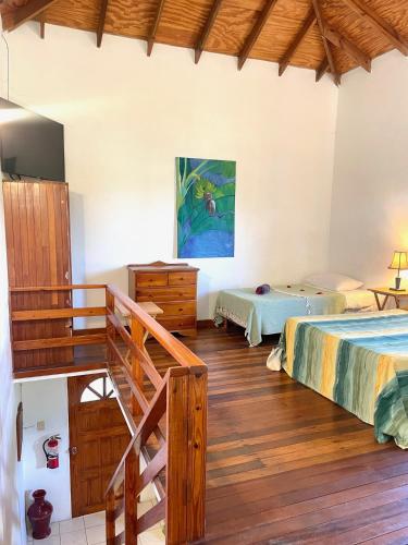 a bedroom with two beds and a wooden staircase at Bananaquit Tobago -Stay Near the Beach in Crown Point