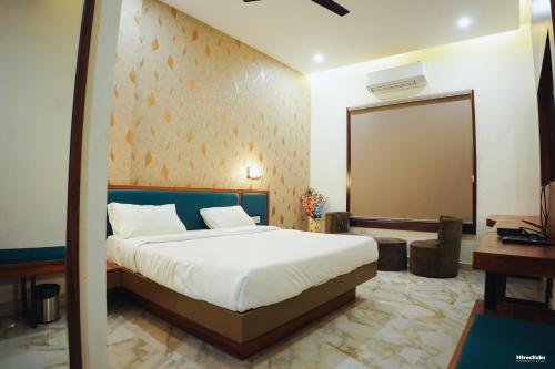 a bedroom with a large bed and a mirror at The Krati Resort & Convention Centre in Bareilly
