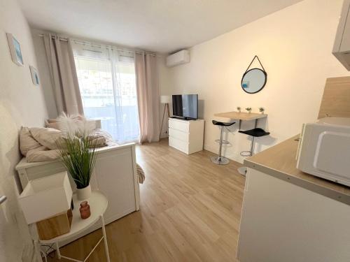 Il comprend un petit salon avec une cuisine et un four micro-ondes. dans l'établissement Studio Ocean Crest avec clim et wifi, à La Grande Motte