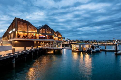 a building on a dock next to a body of water at Casablanca Luxury Retreat near Shellharbour Marina in Shellharbour
