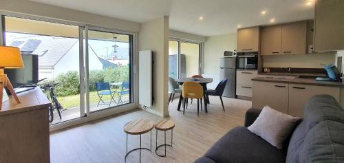 ein Wohnzimmer und eine Küche mit einer Couch und einem Tisch in der Unterkunft Appartement Au calme Quiberon in Quiberon