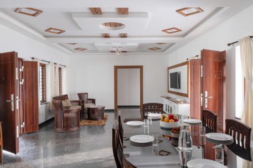 a dining room with a table and chairs at Elora Plantation Villa By Cluster cloud in Idukki
