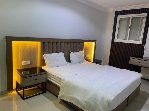 Un dormitorio con una cama grande con sábanas y almohadas blancas. en شقق اجنحة جود للشقق المخدومة, en Riad