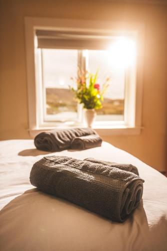 two towels sitting on a bed in front of a window at 10 Cuddy Point, Scalpay in Scalpay