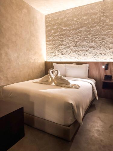 a bedroom with a large bed with a towel on it at Yamato Hostel in Manila