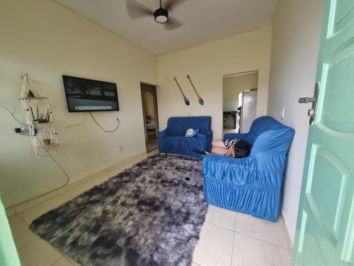 Un uomo sdraiato su una sedia blu in un soggiorno di Casa em Guriri - Carnaval - Semana Santa a São Mateus