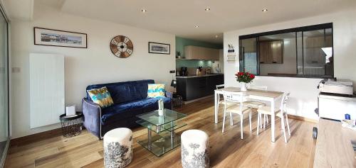 un salon avec un canapé bleu et une table dans l'établissement La Terrasse sur Houat, à Quiberon
