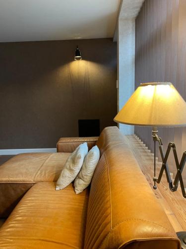 a living room with a couch and a lamp at Gîtes le second à Spa (gîte de 2 et de 5 personnes) in Spa