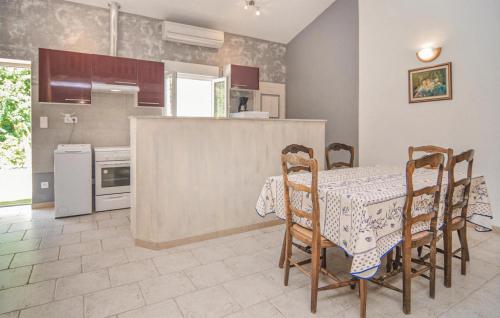 une cuisine avec une table et des chaises ainsi qu'une cuisine avec une cuisinière dans l'établissement Nice Apartment In Le Sambuc With Wifi, à Arles