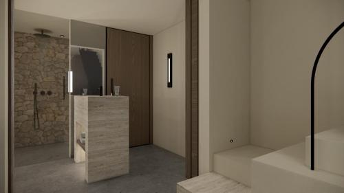 a bathroom with a shower and a stone wall at Agnadema Apartments in Firostefani