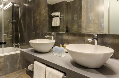 a bathroom with a large bowl sink and a tub at Vincci Liberdade in Lisbon