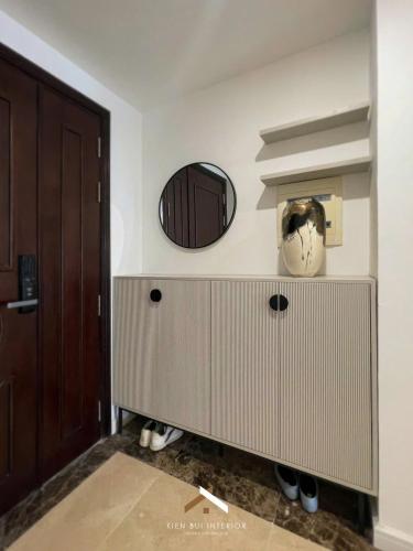 a bathroom with a cabinet and a mirror on the wall at D’Leroi Soleil - Westlake Suite & Apartment in Hanoi
