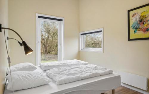 a white bedroom with two beds and a window at Holiday Home Vestervig 44 in Vestervig