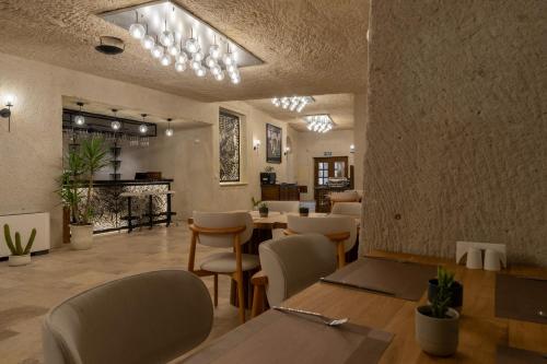 a restaurant with tables and chairs and a fireplace at Asmalı Konak Cave Suites in Urgup