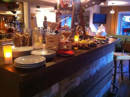 a table with plates of food and candles on it at Ciasa Alpina Relax Hotel in Moena