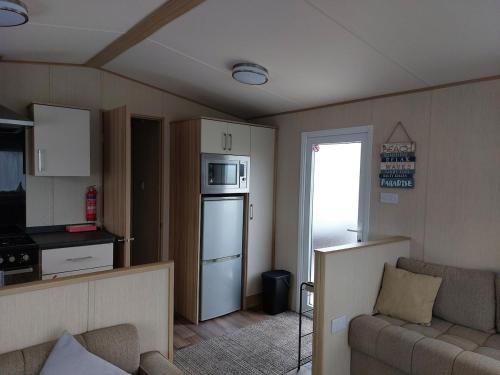a small living room with a couch and a kitchen at Gateway to Cornwall in St Austell