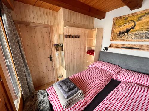 a bedroom with a red and white checkered bed at Chalet Bergdoktor in Amden