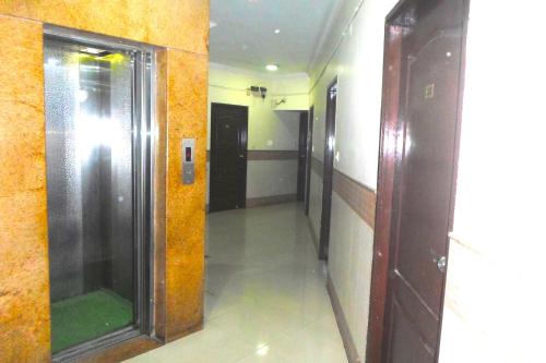 a hallway in a building with a door and a mirror at King Residency in Bengaluru