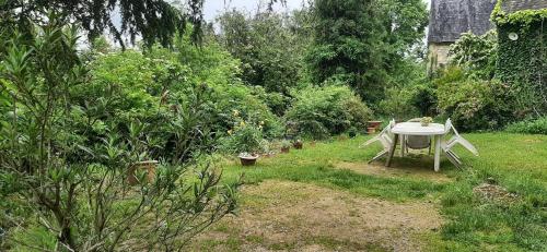 d'un jardin avec une table et des chaises dans la pelouse. dans l'établissement Gîte atypique, à Borrèze